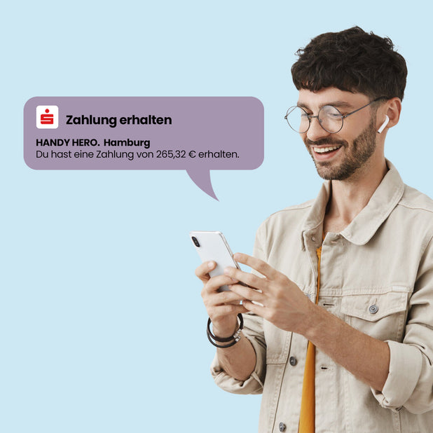 Mann mit Smartphone freut sich über Auszahlung – Zahlung nach Handyverkauf bei Handy Hero